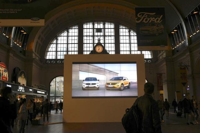 画像: こちらはフランクフルト中央駅の構内です。昨日まではなかったフォルクスワーゲンブランドの大きなディスプレイが設置されていました。人々の様子から、そのサイズの巨大さがわかってもらえると思います。気合いが入っていますね!