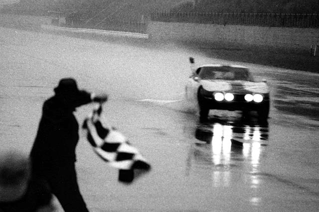 画像: 1967年の富士1000kmゴールシーン、雨中でチェッカーを受ける細谷四方洋/大坪善男組のトヨタ2000GT。