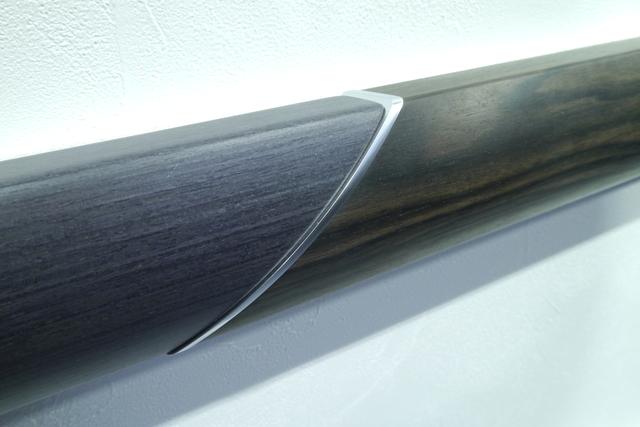 画像: こちらは CX-8 に使われている本杢パネル(左側)と自然の木目の比較展示。本杢パネルのシャープな直線基調の木目は、薄い板を重ねてからカットするという手間をかけることで実現した。