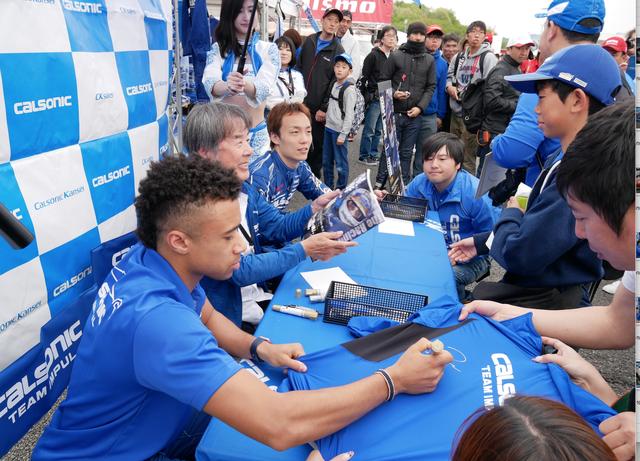 画像: 写真は5月のスーパーGT富士ラウンドのサイン会の模様。ドライバーも揃ってのサイン会に大盛況でした。