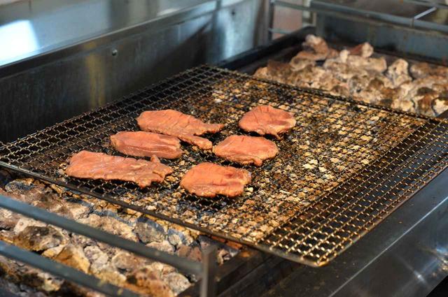 画像: 熱した熔岩石の熱で肉を焼く。遠赤外線効果もあり、調理スペース全体が蒸し風呂のような暑さだ。