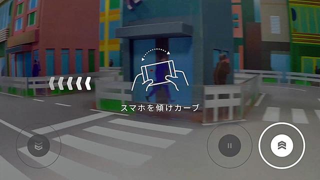 画像: 操作を説明中のスマホ画面。右がアクセル、その隣がブレーキ、左は後退。カーブはスマホを傾けて曲がる。