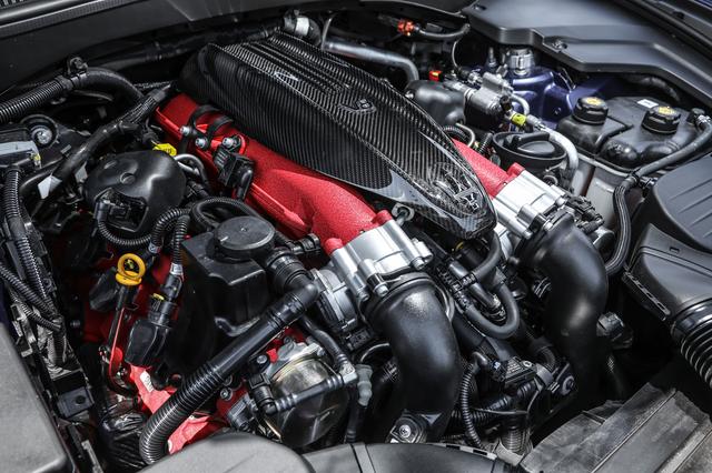 画像: トロフェオに搭載される3.8L V8ツインターボエンジン。カーボンファイバー製のエンジンカバーにV8の文字とトライデントのロゴが入り、シリンダーヘッドとインテークマニホールドは赤くペイントされる。