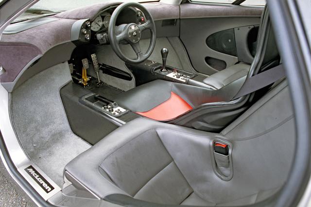 画像: 運転席右にシフトノブとエアコンのスイッチ類、左にパーキングブレーキとオーディオのスイッチ類が備わる。
