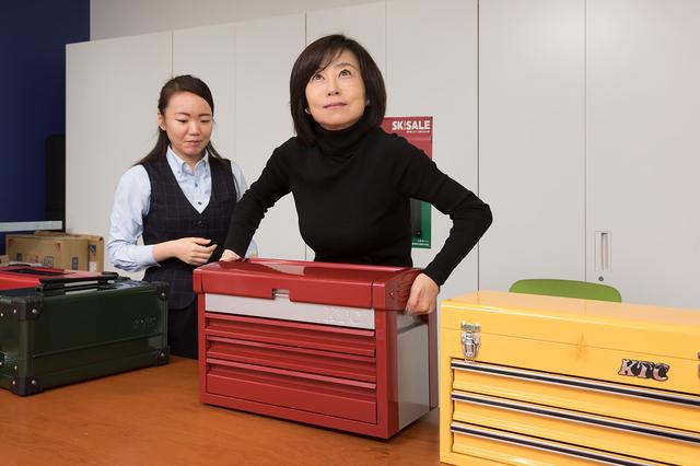 画像: EKR-103/EKR-113の持ちやすいビルトインハンドルを自ら体験する飯田レポーター。