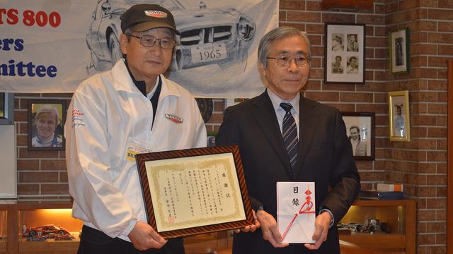 画像: 寄付金贈呈により交通遺児育英会より感謝場を受取った杉山代表(左)。隣は交通遺児育英会の土肥常務理事。