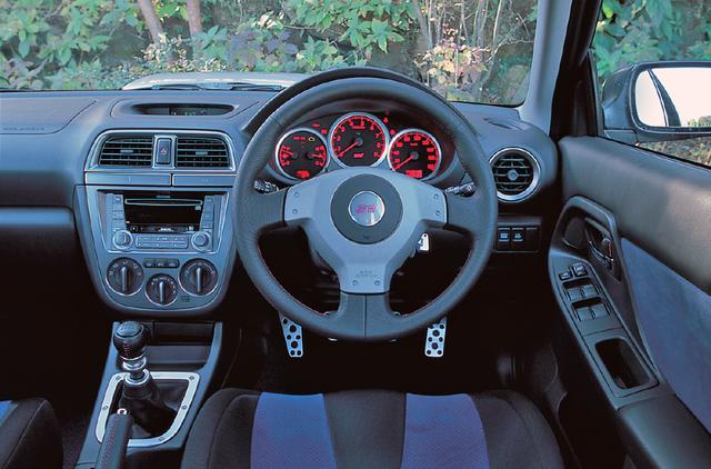 画像: STiはスポーツ走行に最適な375mmφの小径ステアリングを採用。レッドルミネセントメーターも採用された。