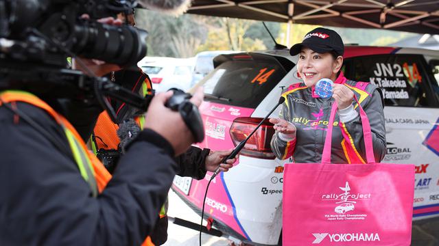画像: メディアの取材に答える竹岡圭さん。ノベルティのバッグも鮮やかなピンク色。