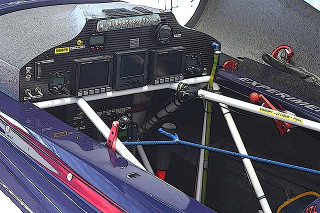 画像: フルデジタルディスプレイが2017年型の主流。計器も厳正に規定通りでなければならない。ただしディスプレイの配置と大きさは、パイロットの好みだそうだ。整備中に不要に操縦桿が動かないよう、ロープで固定してある。エッジ540が鋼管フレーム+カーボン張りであることが分かる画像でもある。