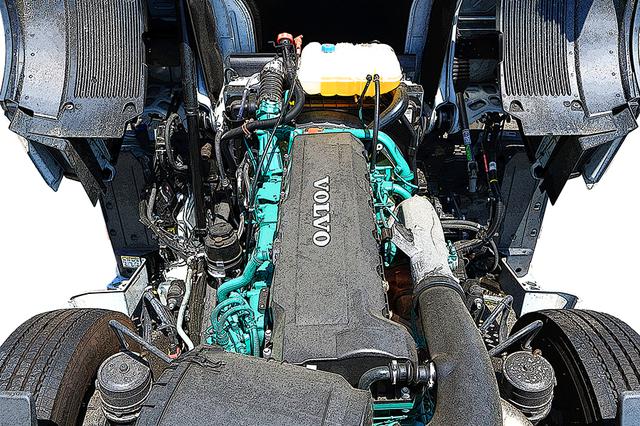 画像: キャブ直下に納まる、緑色の12.7L 直6ディーゼルエンジン。巨大なキャブは4カ所のエアサスで懸架される。画面下方、前輪の内側にブレーキチャンバーが見える。