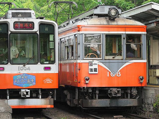 画像: 隣の108形から46年ぶりの1981年に新造された1000形ベルニナ号。特徴的な屋根上冷房機器に見える大型抵抗器は踏襲されている。運転席下のスカート(排障器)に見えるのが撒水機。駆動方式は、現代の主流である並行カルダン式。車内連結部に冷房装置を搭載している。