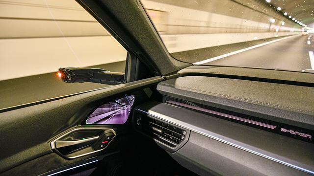 画像: 走行車線へ戻る際のバーチャルエクステリアミラー表示。左下部にアウディサイドアシストによる側方の状態が色で示される。グリーン表示は安全の意味。カメラ本体のアンバーはウインカーの点滅。
