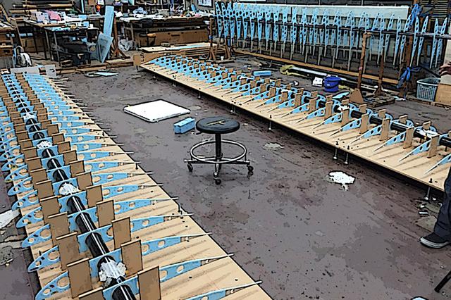 画像: カーボンパイプの主桁に整然と組まれた、ハンドメイドの主翼リブ。ひとつが3層構造で、肉抜きも施された超軽量構造。尾翼も同じ構造で作られる。根気のいる作業だ。