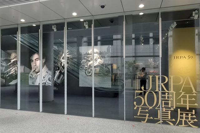 画像: 会場に到着するとまず大きなモノクロ写真群に圧倒される。場内からも至近距離で見られるのだが、これはあくまでも場外向けの展示である。