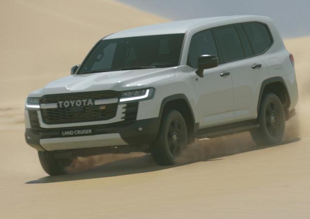 画像: 砂漠を疾走する新型ランドクルーザー(300系)。フロントグリルには「GR」のエンブレムも見えるが、詳細は不明。