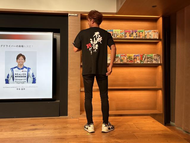 画像: 壇上において上着を脱ぎ、ファンお馴染みの名台詞が書かれたTシャツを披露する平手晃平選手。作品に対する思い入れの程を、自身なりのスタイルでアピールした。