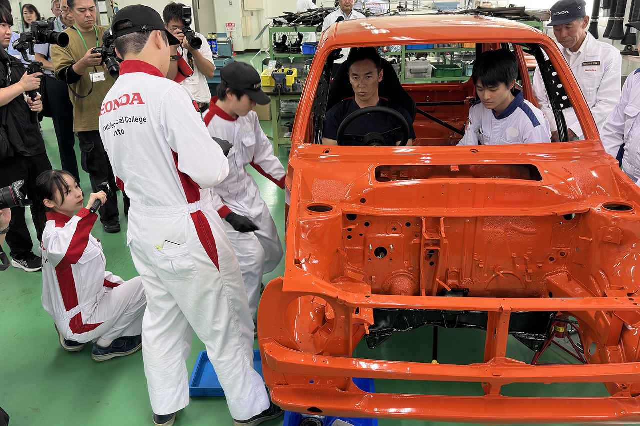 画像: 参加車両の75年式シビックRSでシートフィッティングを行う佐藤琢磨選手と参加生徒たち。佐藤選手の要望にすぐに応えるサポート力を垣間見ることができた。