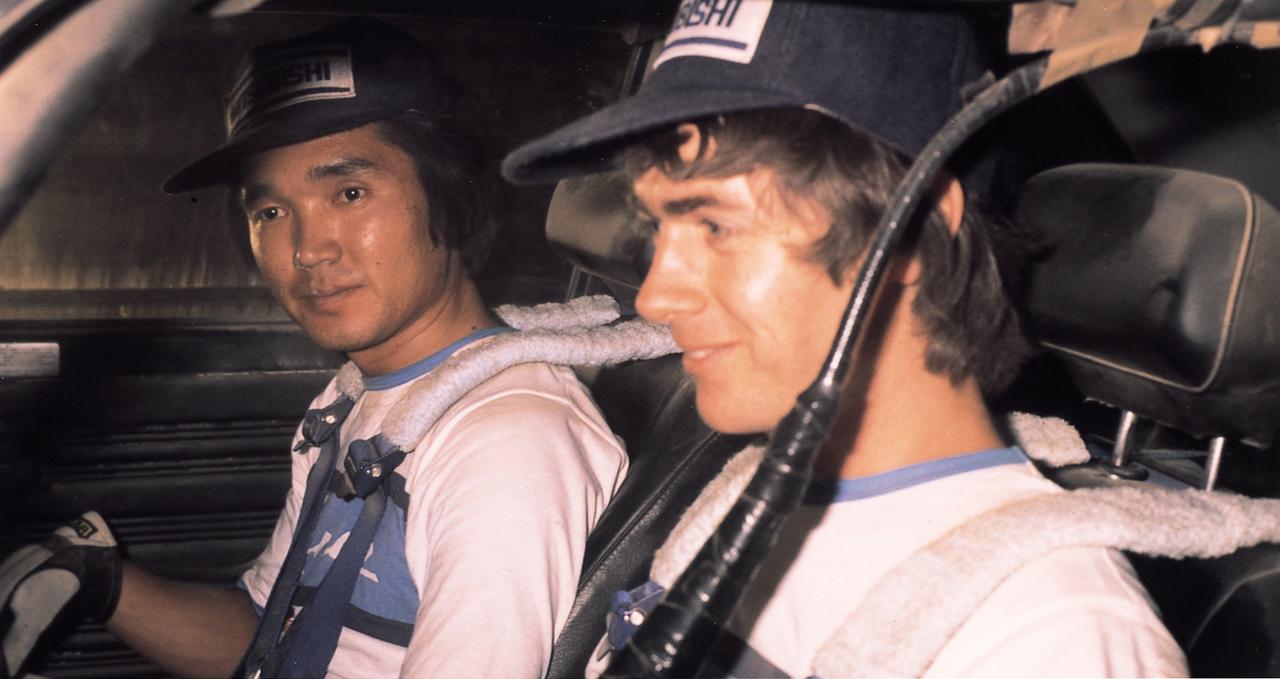 画像: 三菱自動車の顔となったラリードライバーの篠塚建次郎（左）。これは1977年サザンクロスラリーでのスナップ。