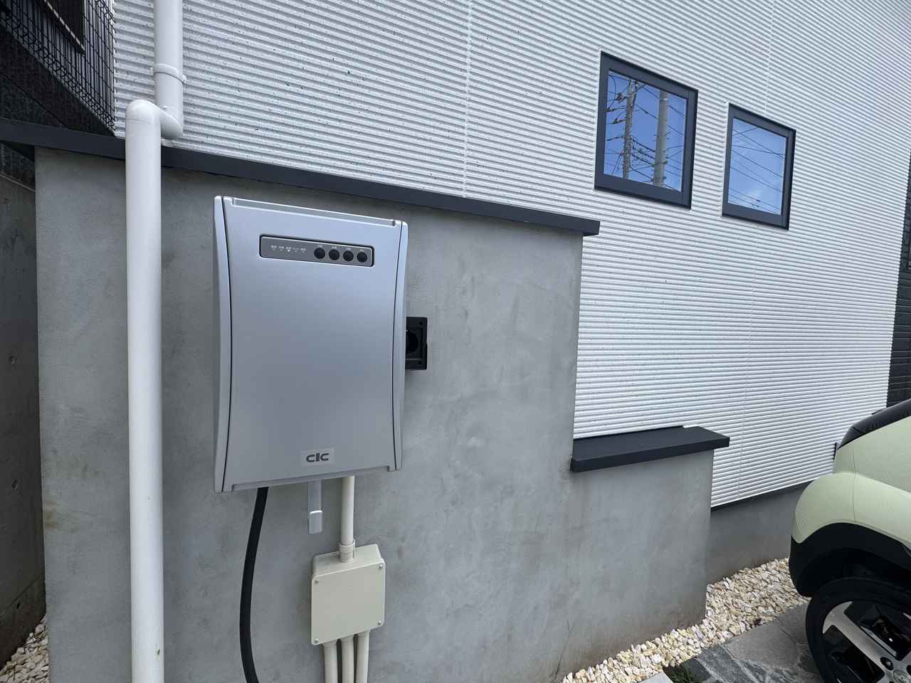 画像: 住宅のパーキンスペース近くに設置された室外EVユニット。電源は、再生可能エネルギーの太陽光を使っている。