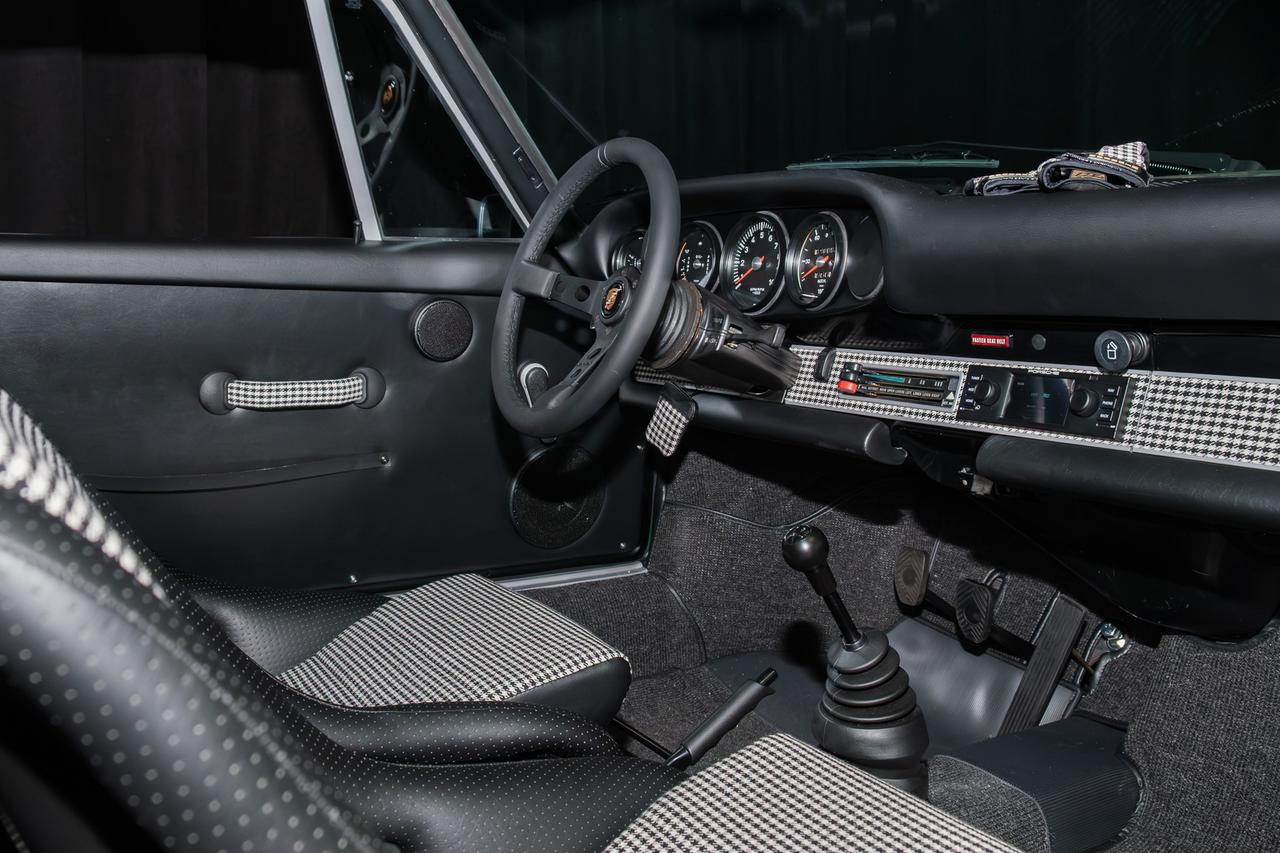 画像: 「1973 ポルシェ 911T RSR トリビュート」のインテリア。ハウンドトゥース(千鳥格子)生地があしらわれたダッシュトリム、964 RS アメリカのドアプルなど、細部にまでこだわった仕上がりとなっている。パワーユニットには2.8Lエンジンを搭載し、燃料噴射システムを組み合わせることで280ps以上を発生するという。