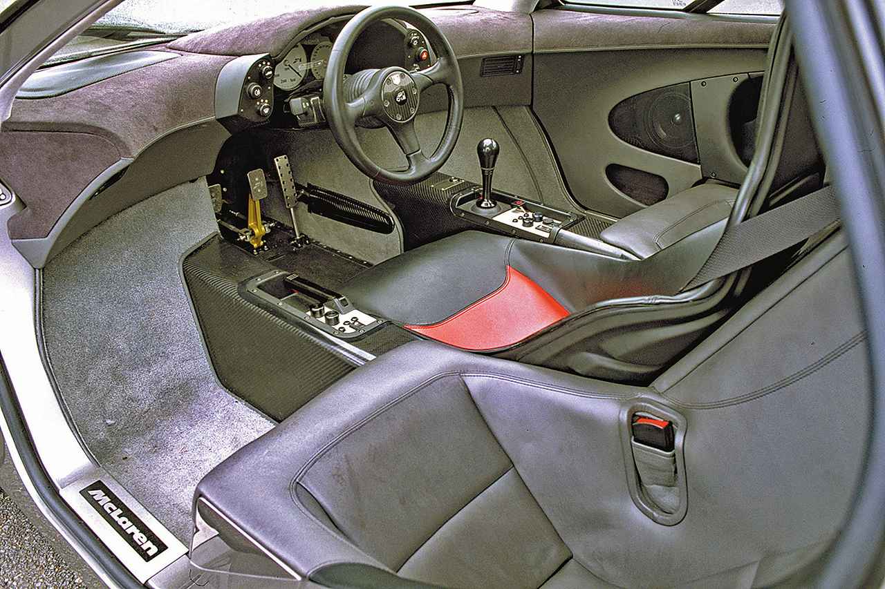 画像: 運転席右にシフトノブとエアコンのスイッチ類、左にパーキングブレーキとオーディオのスイッチ類。シートレイアウトはユニークな3シーター。