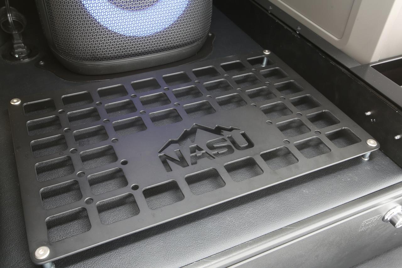 画像: 荷室にはNASUロゴ入りのスチールプレートを装備。ギア固定にも使える実用性重視の設計だ。