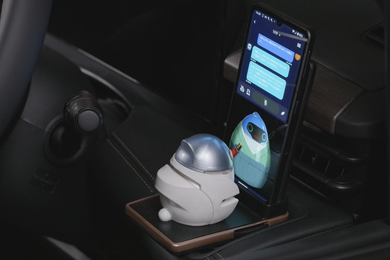 画像: 車載エージェント「AutoDJ」のフィギュアとスマートフォン画面に映るエポロ。実際に会話しているかのような親近感ある演出が特徴だ。
