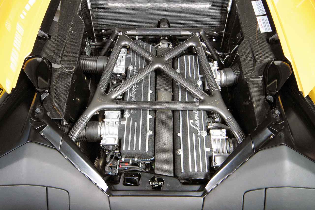 画像: エンジンは60度V12のDOHC48バルブ。鋼管スペースフレームに補強として貼り付けられたCFRPパーツも見える。