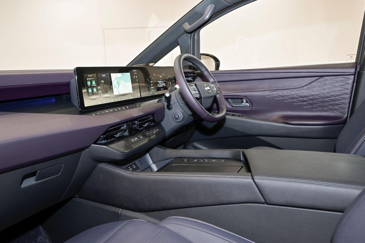 画像: 幅広で高いコンソールにより広い視界を確保。同時に、オーナーの満足感を一層高めている。静電スイッチ類は、木目調パネルと一体化。メーターディスプレイにモーターの出力制御とブレーキ作動の状態が表示され、ドライバーは制御状況を視覚的に確認できる。