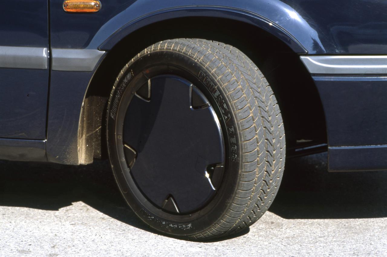 画像: タイヤサイズは185/60R14。ボディカラーと同色のフルホイールカバーが装着され、全体をファッショナブルなイメージとした。