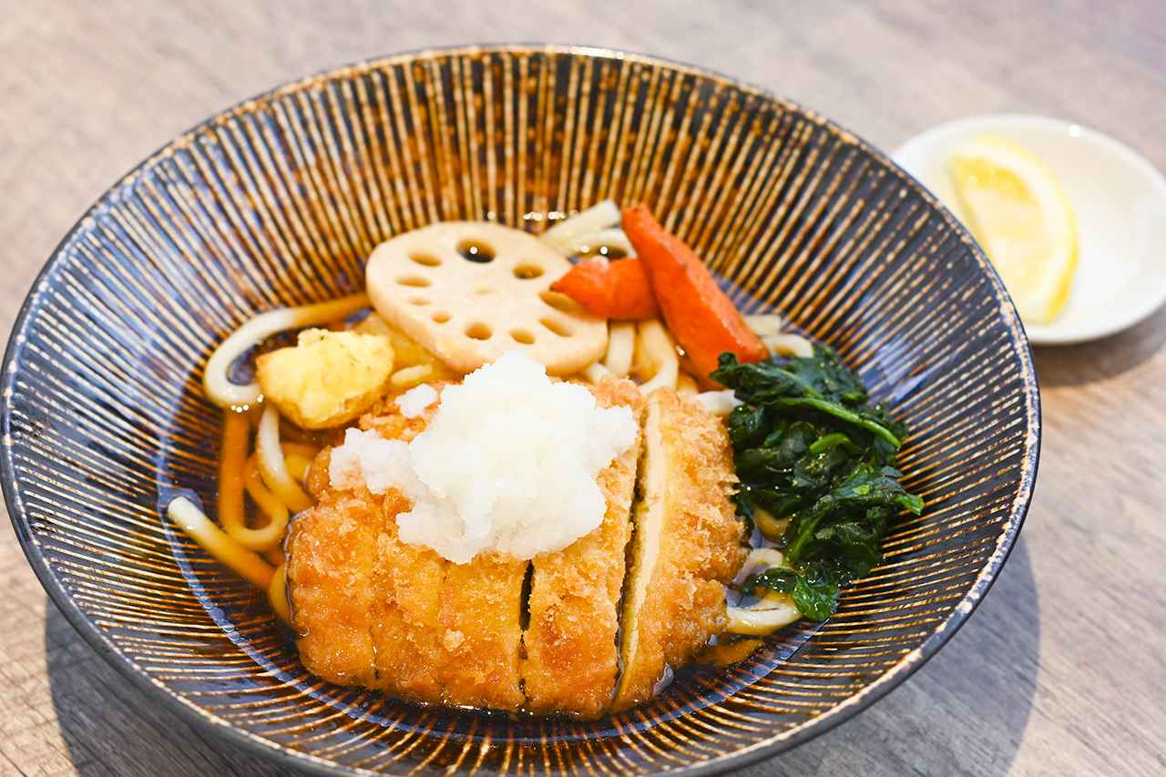 画像: フードコート内「みかも庵」の「佐野の母ちゃん煮うどん」（1200円）。ぶっかけうどんの上に、サクサクのチキンカツが載っている。