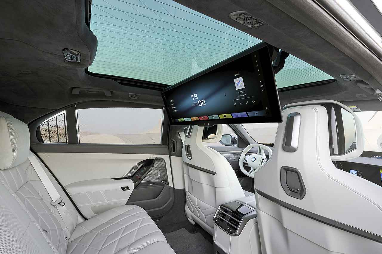 画像: パノラミックガラスサンルーフや、31.3インチのBMWシアタースクリーンなどを備えたリアシート。車内でビデオ会議も可能だ。