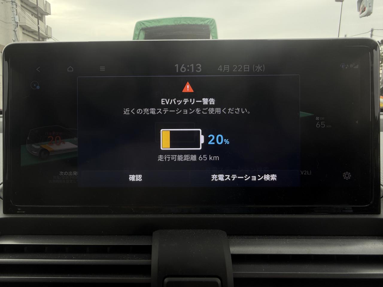 画像: 平均電費7.3km／kWの状態で充電残量20％になると走行可能距離は65kmと表示される。ここで「充電ステーション検索」を選ぶと、近くの充電ステーションの候補が中央のディスプレイに表示される。