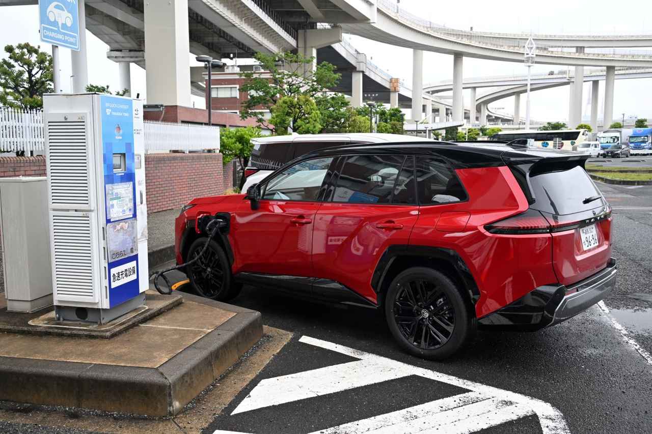 画像: 大黒PAで充電中。新型RAV4は「電力を使う」のも得意で、付属のヴィークルパワーコネクターを使えば合計1500Wまで対応する100V外部給電用コンセントとしても活用できる。非常時にはガソリン満タン・バッテリー満充電の状態で約6.5~7日間ほどの給電に対応するという。