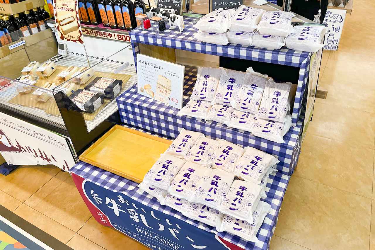 画像: スーベニアショップ arude’「あるで」で販売される「牛乳パン」。少年・少女と牛が描かれた白いパッケージが目印だ。