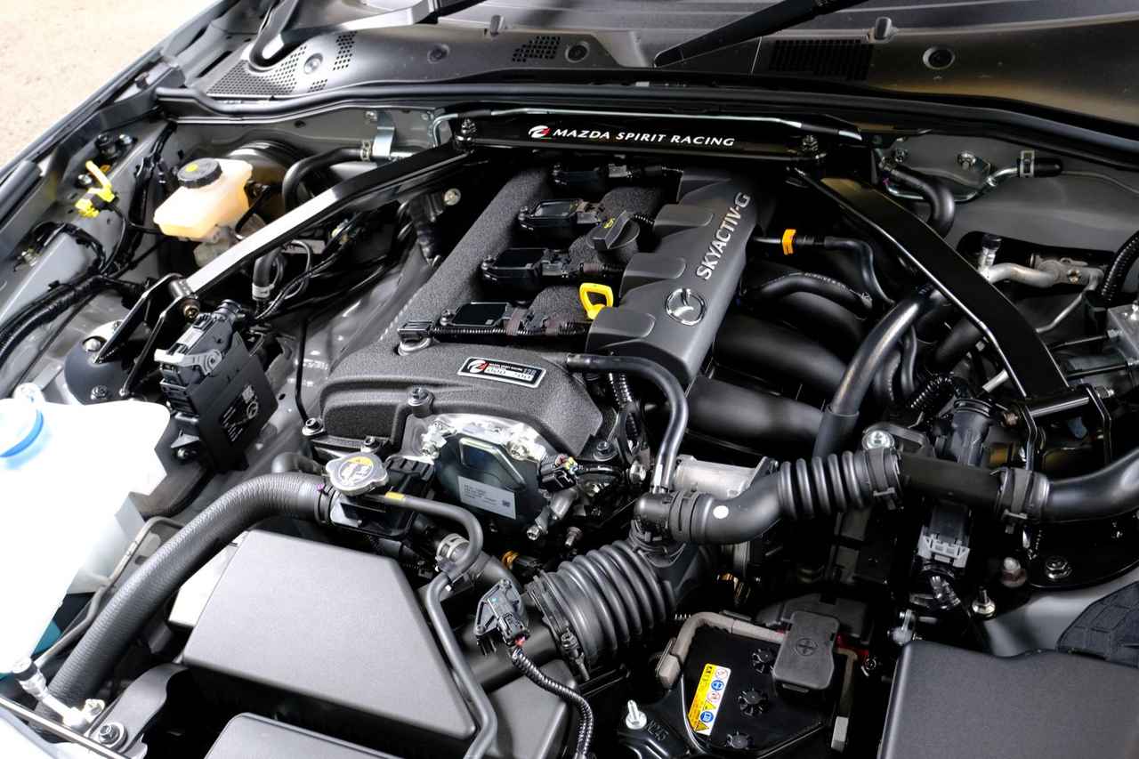 画像: RFに設定されたSKYACTIV-G 2.0（PE-VPR［RS］型）を専用チューニング。コアモデルは最高出力184ps／最大トルク205NmともにRFと同等スペックだが、出力制御やスロットル制御は「より気持ちいい」方向で変更されている。ヒールアンドトゥのアシストコントロールなど、乗りやすさにもこだわった。写真の12R用（ヘッドカバーを手塗りの結晶塗装で差別化）はさらに、最高出力を200ps／最大トルクを215Nmまで引き上げている。がっしりと力強いストラットタワーバーも、12R用の装備だ。