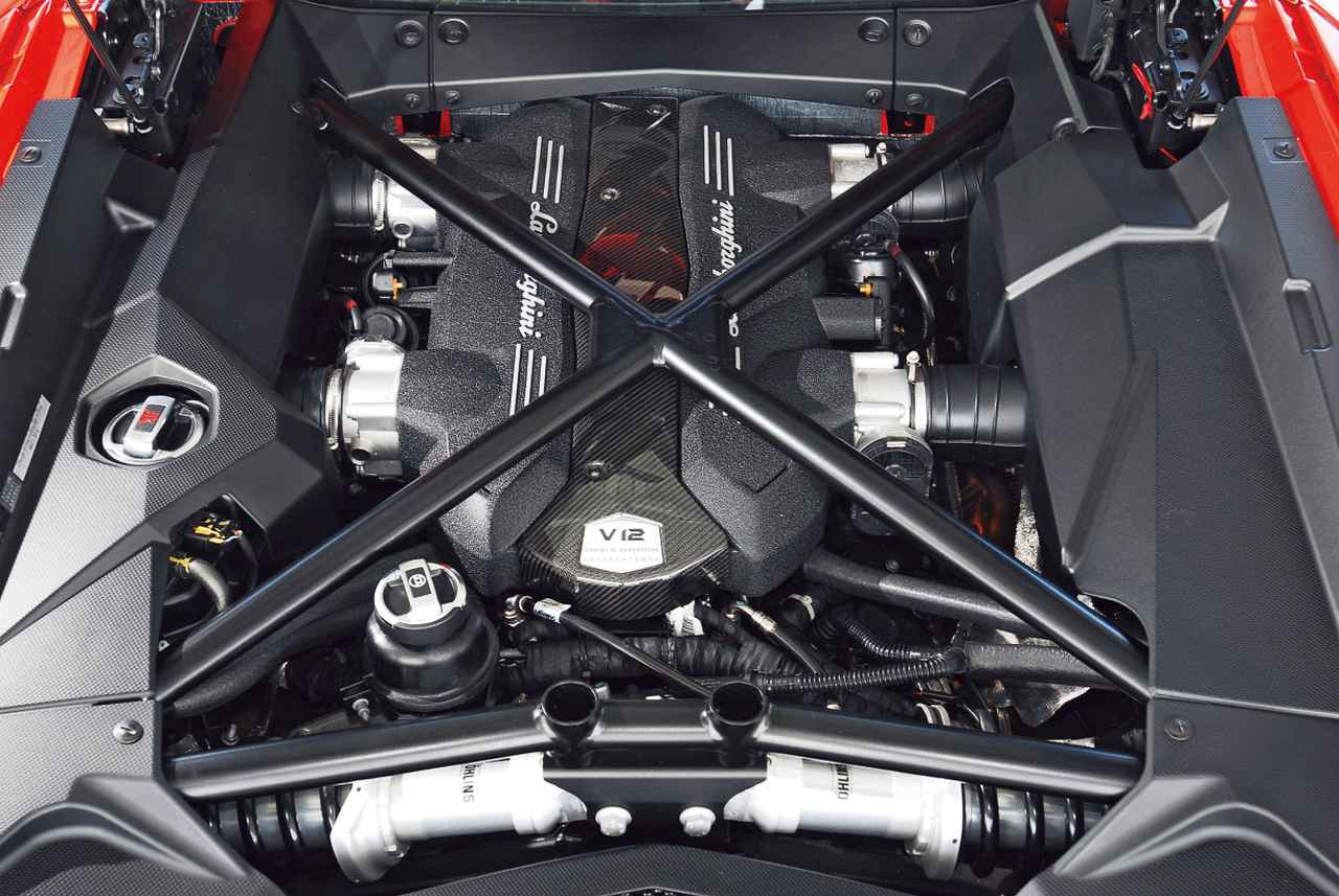 画像: アヴェンタドールのためだけに新たに開発されたという6.5L V12気筒エンジン。8250rpmで700psを発生する。手前にプッシュロッド式サスのダンパー(オーリンズの固定レート)が見える。