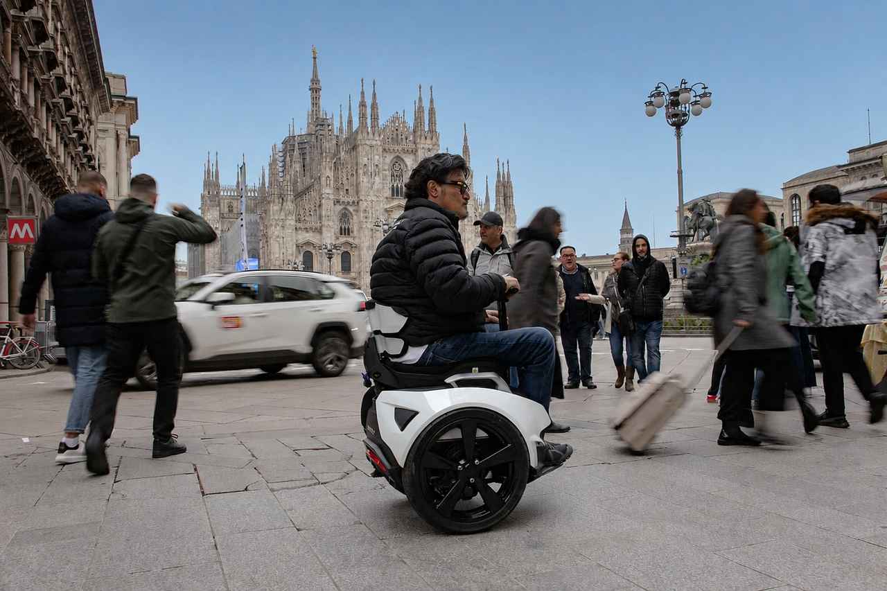 画像: ミラノの大聖堂前の広場を行くGenny Zero。クルマのそれに近いワイド感を誇る車輪を左右に一つずつ備える