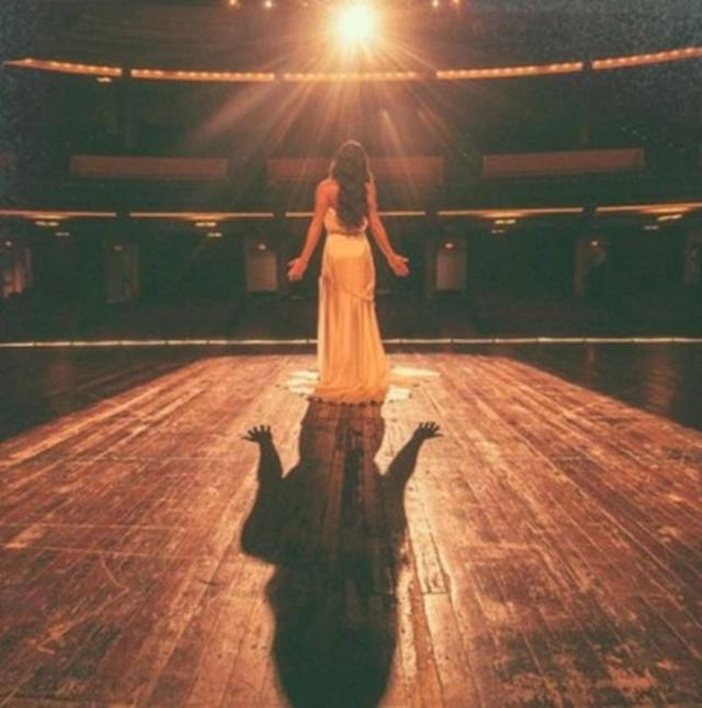 画像: リア・ミシェル 、劇場のステージに立ちスポットライトに照らされて。©Lea Michele