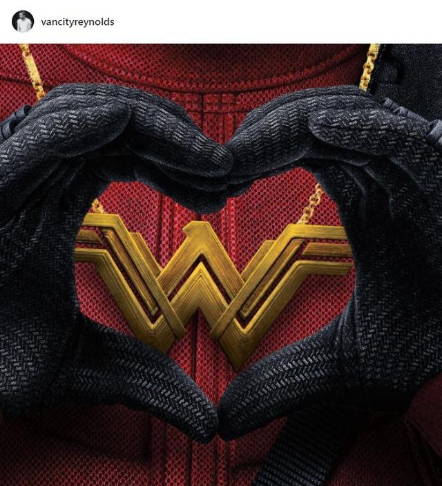 画像: ライアンは、ワンダーウーマンのネックレスを着けて手でハートマークを作るデッドプールの写真を一緒に投稿