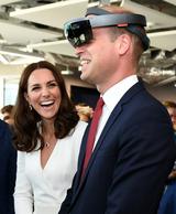 画像: 若手実業家が集まるレセプション・イベントでバーチャルリアリティを体験できるVRゴーグルを着用するウィリアム王子を楽しそうに見守るキャサリン妃。