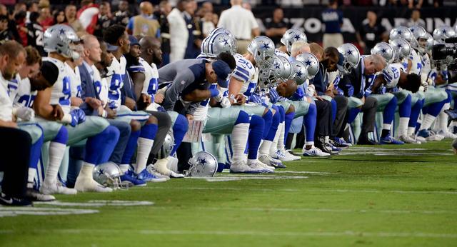 画像: 9月25日に行われた試合で、国家斉唱中にひざまずくダラス・カウボーイズの選手たち。