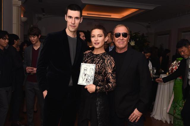 画像: (左から)英国アーティストのクリム・エバンデンと、クリムが描いたイラストを持ったケイト・ハドソン、マイケル・コース