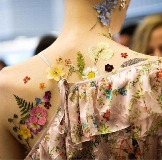 画像: バックステージでは用意されたたくさんの押し花からメイクアップアーティストたちが1つ1つ手作業でモデルの顔やボディに貼り付けていた。