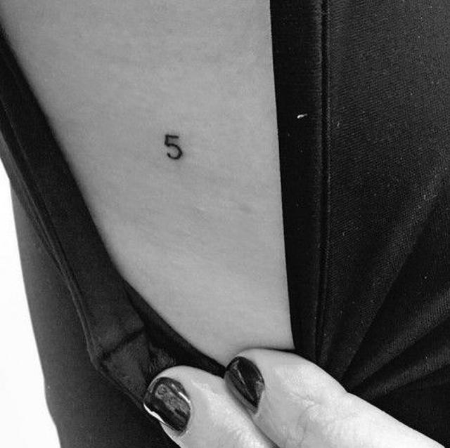 画像: あばらの側面に入った「5」のタトゥー。