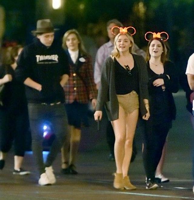 画像: メーガンとクロエはミニーの耳の形の光るヘアバンドを着けて夜のディズニーランドを満喫。黒いロゴ入りパーカーを着てハットをかぶっているのがブルックリン。