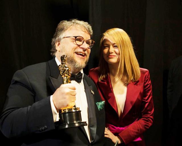 画像: バックステージでのギレルモ・デル・トロ監督とエマ。