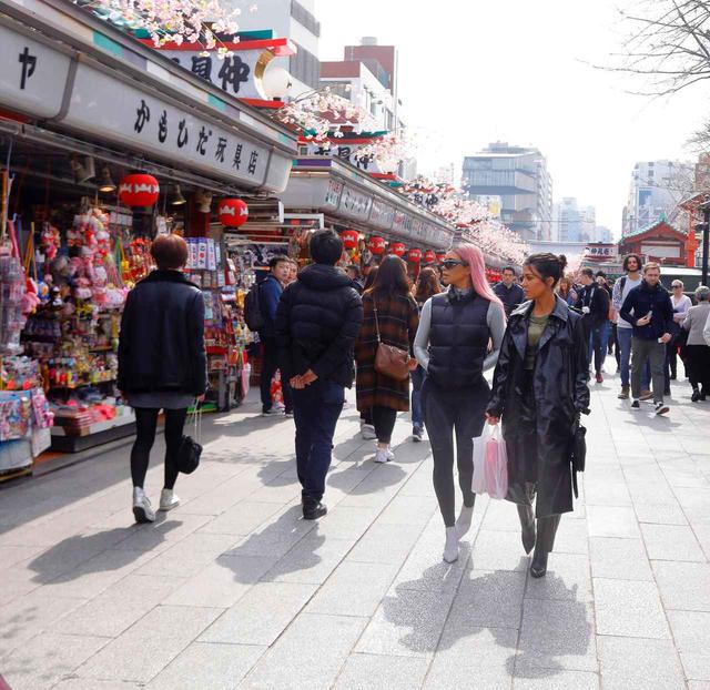 画像: 浅草寺の門前へと続く仲見世商店街に立ち並ぶ店を物色するキムと姉のコートニー。