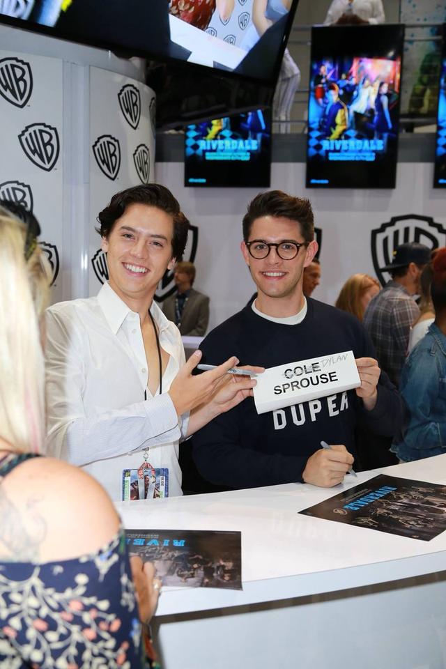 画像: 『リバーデイル』で共演する俳優のケイシー・コットと「ディラン・スプラウス(Dylan Sprouse)」と書き換えたネームプレートを持って、写真撮影に応じるコール。