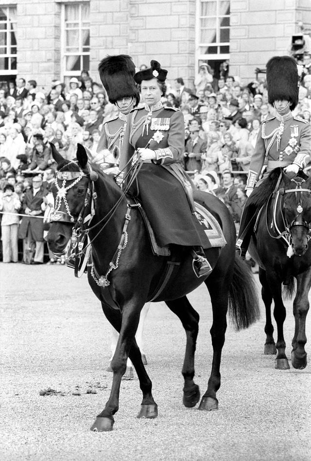 画像: 1977年の軍旗分列行進に馬に乗って登場した若き日のエリザベス女王。